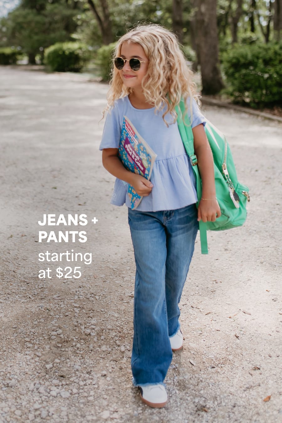 Model wearing Stitch Fix kids clothes including blue shirt and blue jeans. Text reads: JEANS + PANTS starting at $25.