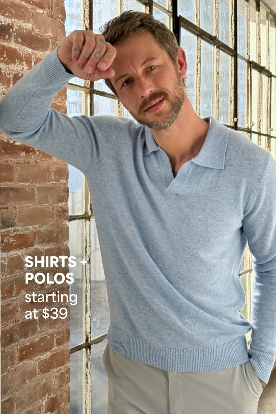 Model wearing Stitch Fix men’s clothes including blue sweater polo and tan pants. Text reads: Shirts + polos starting at $39.