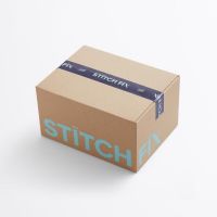 A Stitch Fix box with navy packaging tape and a mint colored logo wrapping two sides of the box.