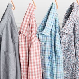 Shirts in a variety of prints hung on a rack.