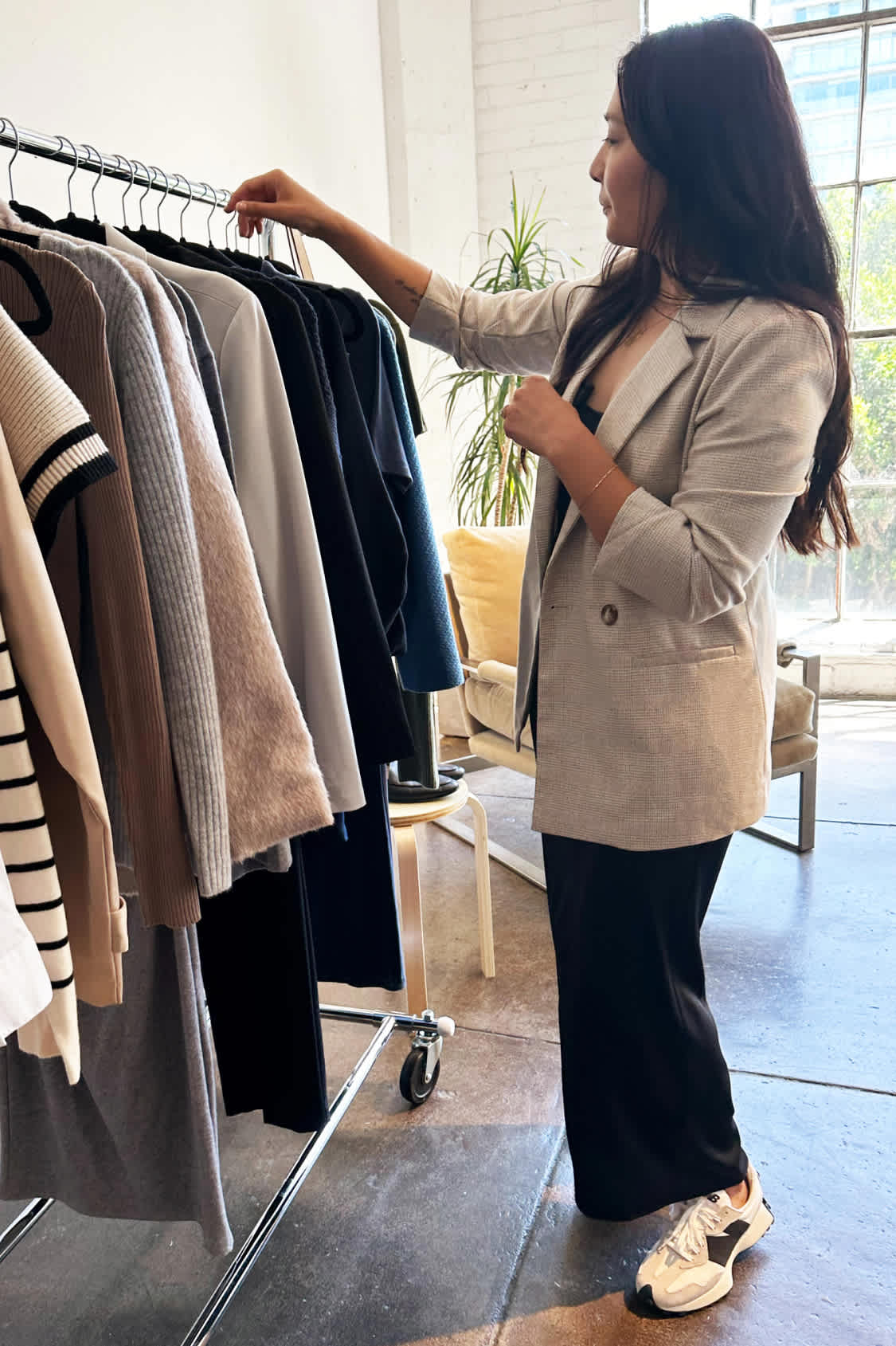 Model with Stitch Fix women’s clothes including a tan blazer, floral shirts and jeans.
