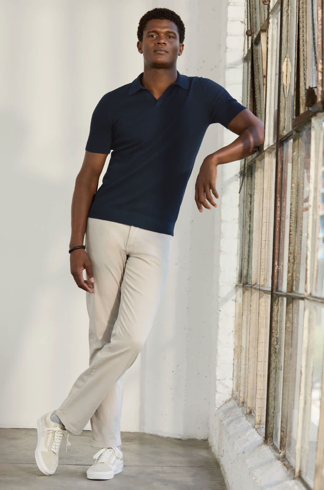Model wearing Stitch Fix men’s clothes including navy blazer, olive button-down and dark-wash jeans. Text reads: MEN. 