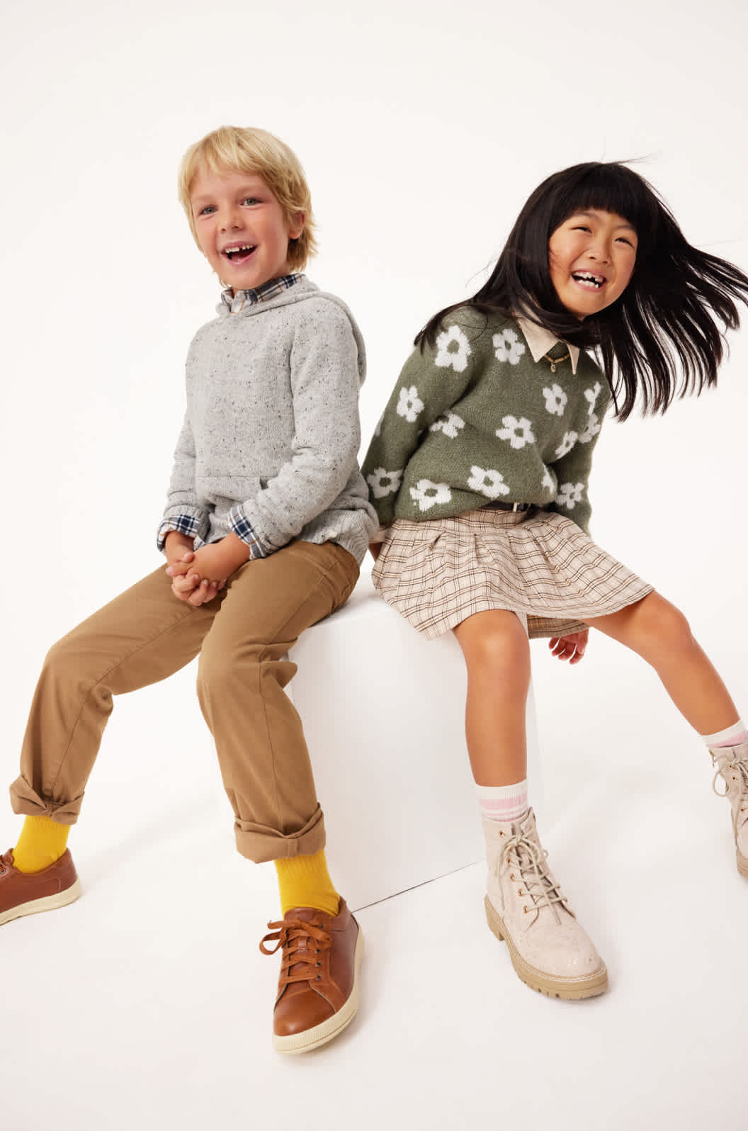 Model wearing Stitch Fix girl’s clothes including crewneck pullover and skirt. Text reads: KIDS.