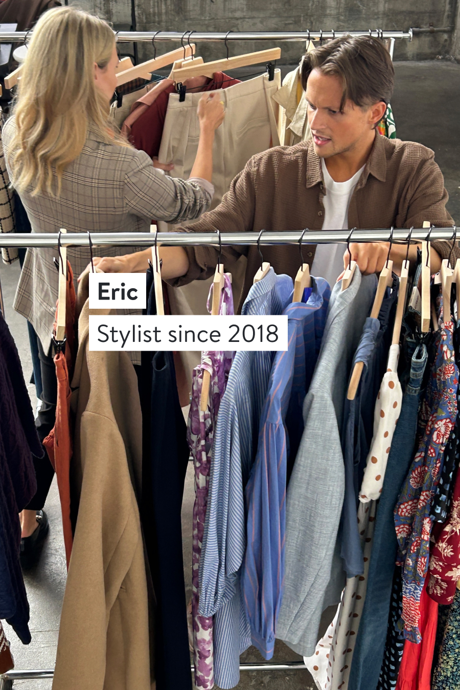 Eric, Stylist since 2018. Two Stitch Fix Stylists selecting items from clothing racks including chambray shirts, blazers and patterned dresses. 